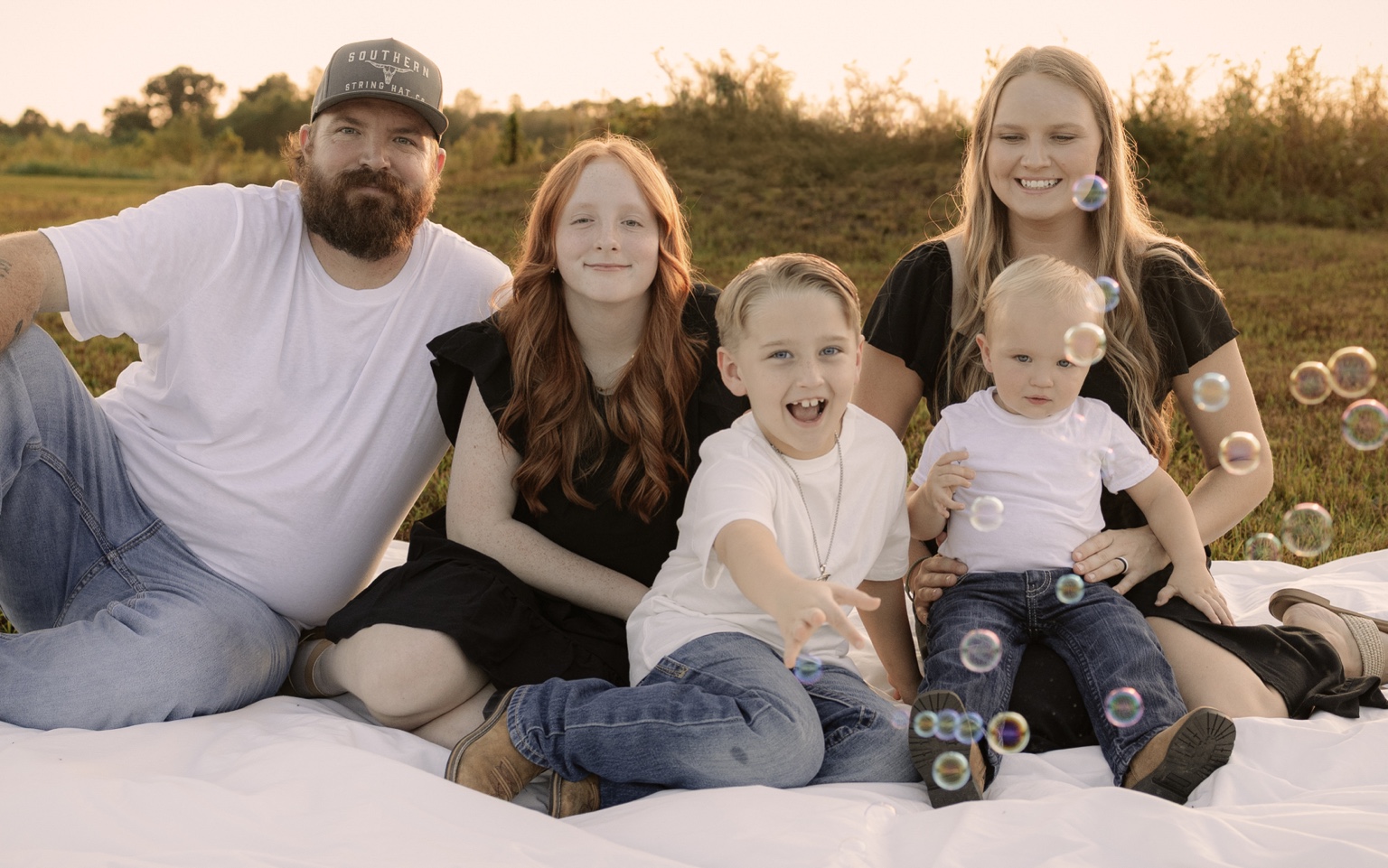 A family sharing a joyful evening together with bubbles in the golden light